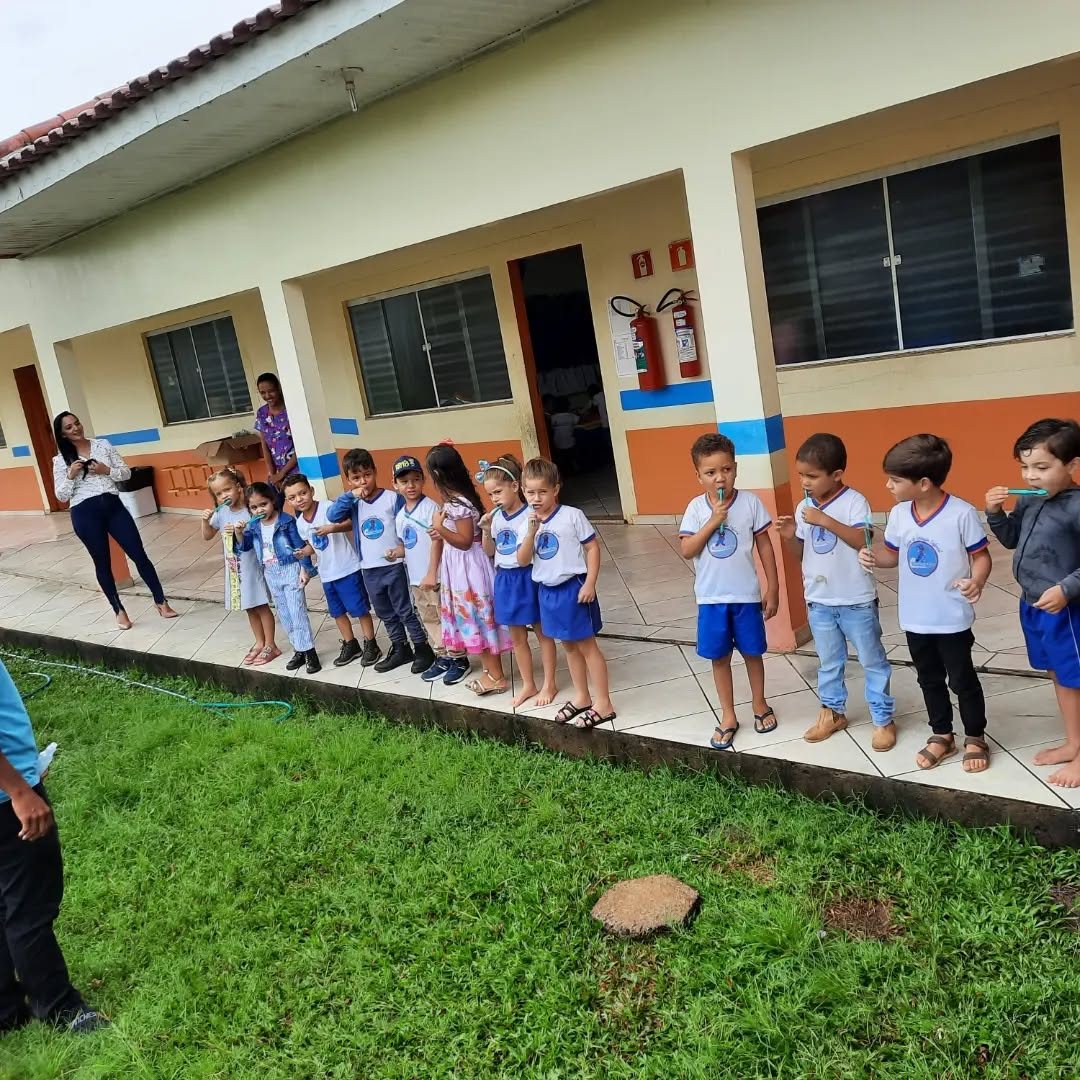 Crianças em fila no pátio do CEI Castorzinho, com o prédio da escola ao fundo